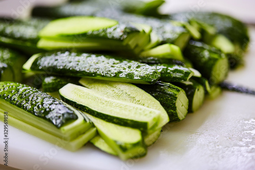 Sliced cucumbers on cutting board. Vegetables ready for salad. Tasty diet Vegetarian food