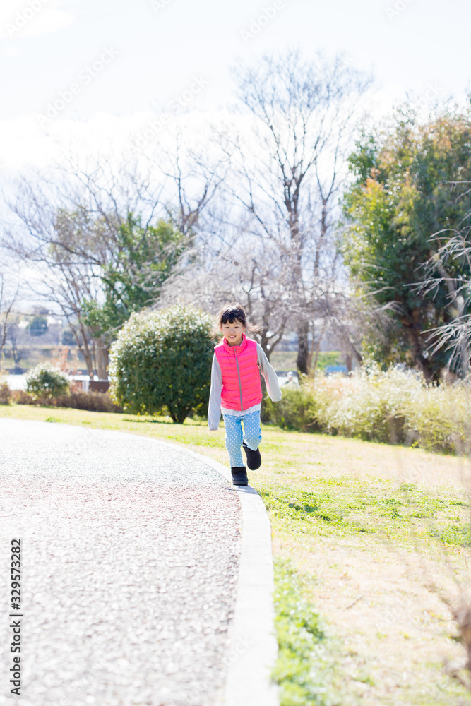 春の公園で遊んでいる子供