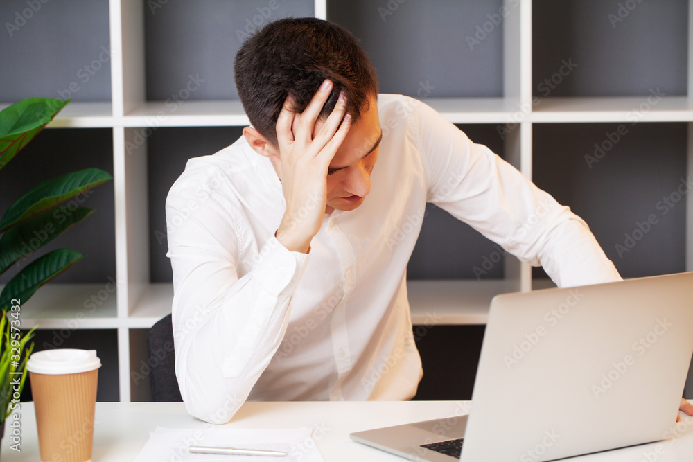 Tired man working at the computer in the office Tired man working at the computer in the office