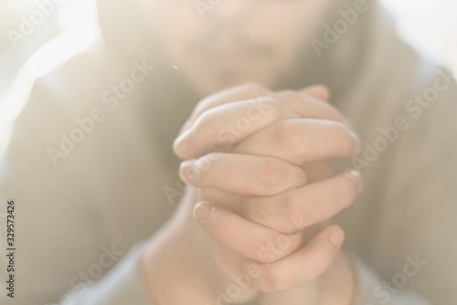 Bilde på lerret Bearded adult man praying to God sitting at home in the sunbeam