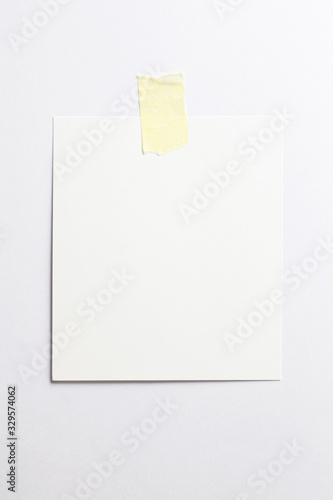 Blank polaroid photo frame with soft shadows and yellow scotch tape isolated on white paper background as template for graphic designers presentations, portfolios etc.