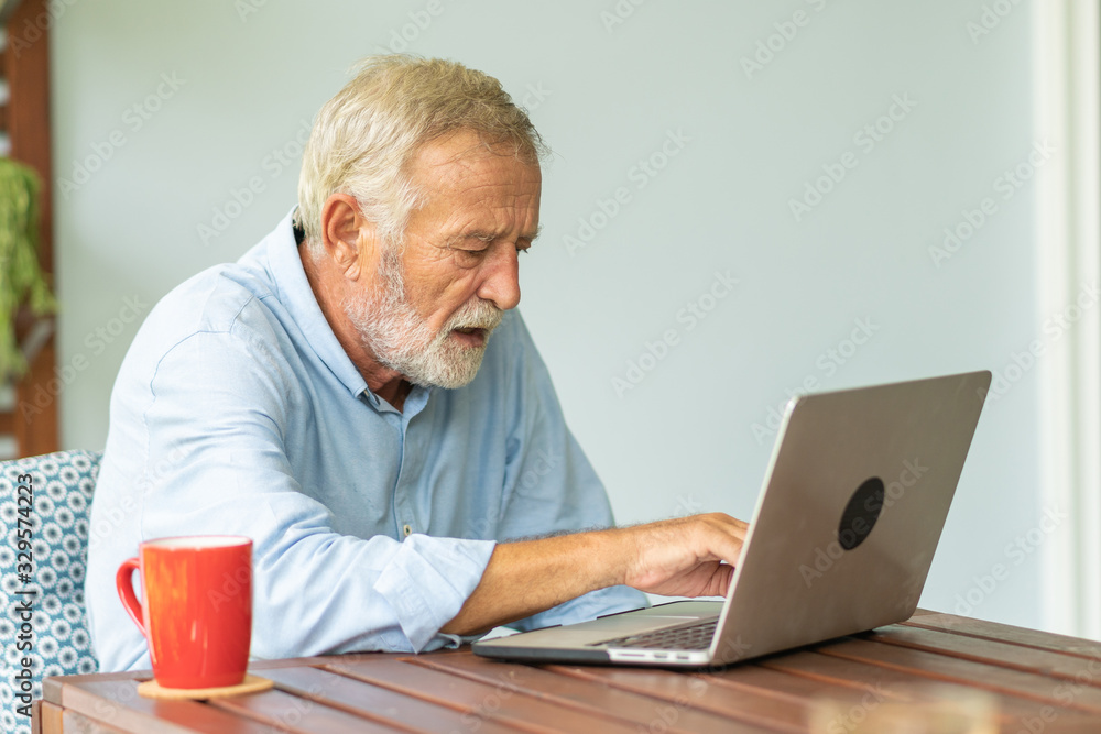 Portrait senior man using laptop for working at home, Freelance concept - Image Portrait senior man using laptop for working at home, Freelance concept - Image