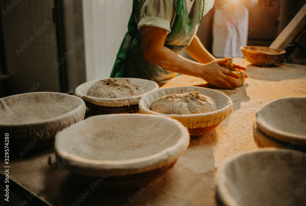 Female baker kneading dough in a bakery Female baker kneading dough in a bakery