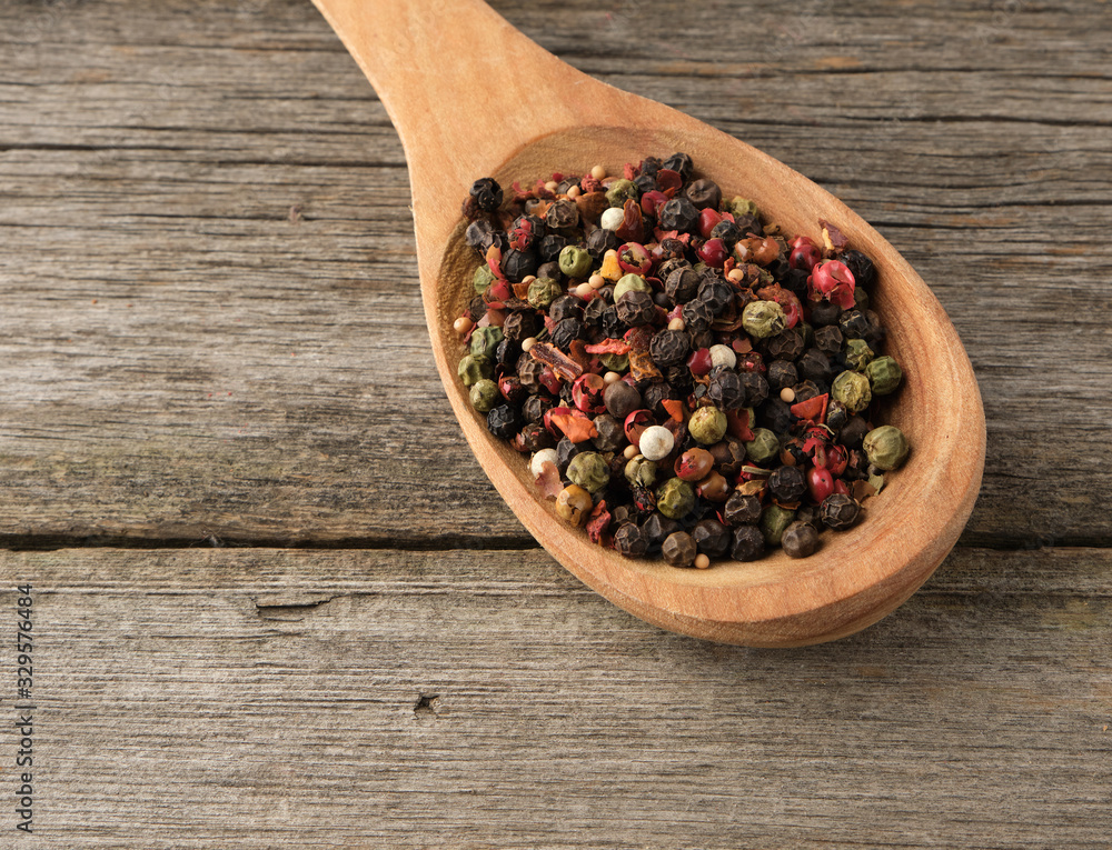 mix of dry balls of various peppers in a wooden spoon mix of dry balls of various peppers in a wooden spoon