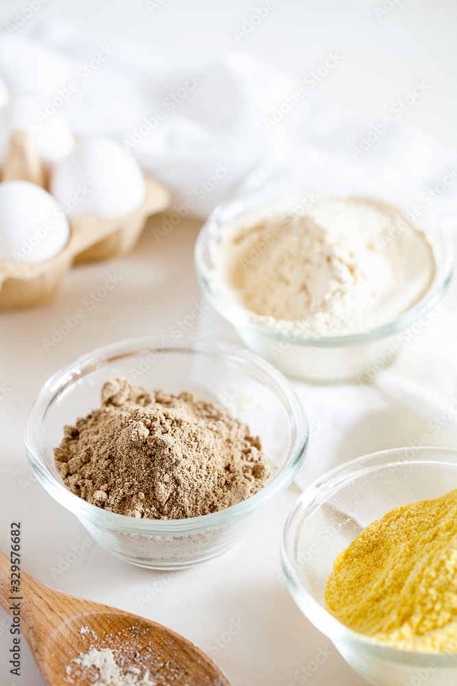 Various gluten free flour corn,sesame,oat,coconut in bowl on white background.Alternative to wheat flour for keto paleo diet.Healthy eating,dieting,balanced food concept.Vertical orientation,top view Various gluten free flour corn,sesame,oat,coconut in bowl on white background.Alternative to wheat flour for keto paleo diet.Healthy eating,dieting,balanced food concept.Vertical orientation,top view