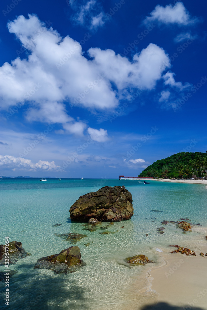 Blue sea on a white beach with blue sky in the background at Pulau Kapas