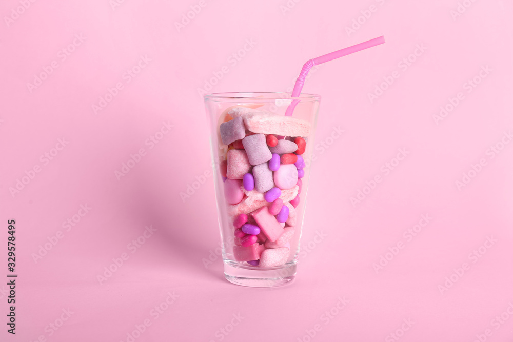 Glass with different chewing gums on color background Glass with different chewing gums on color background