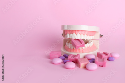 Plastic jaw and chewing gums on color background