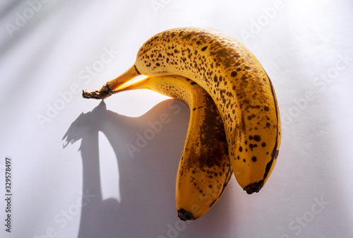 Two ripe bananas on white table against sunlights 3