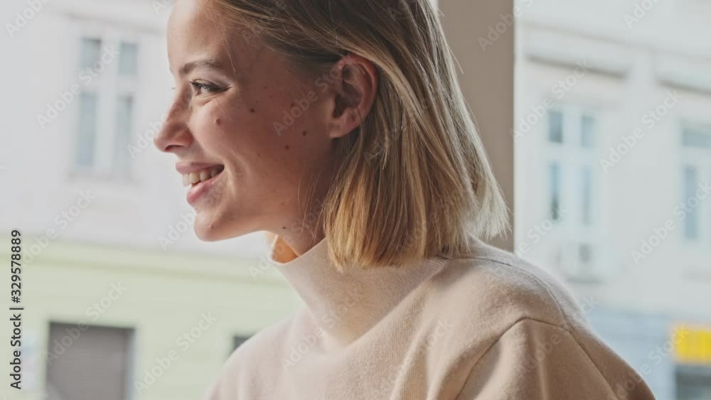 Beautiful young blonde woman using mobile phone while sitting in the cafe indoors and drinking coffee Beautiful young blonde woman using mobile phone while sitting in the cafe indoors and drinking coffee