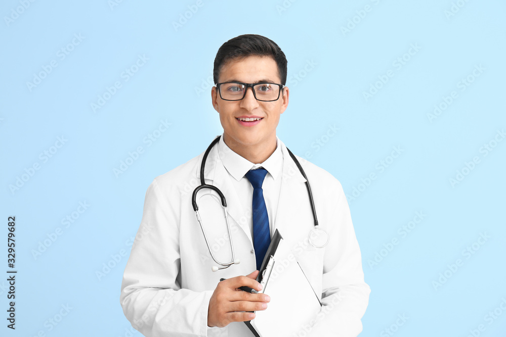 Handsome male doctor on color background