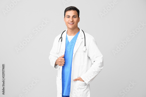 Handsome male doctor on light background