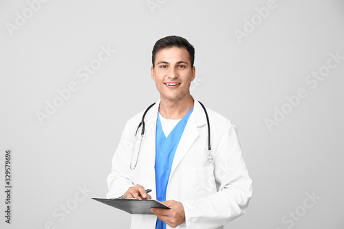 Handsome male doctor on light background