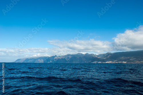 Port and city of Los Gigantes. View of the rocky coast from the sea.