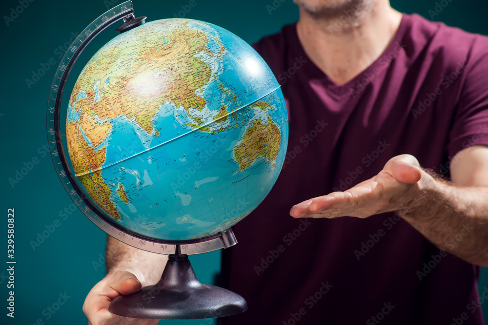 A man in t-short holding globe. Travel and education concept A man in t-short holding globe. Travel and education concept