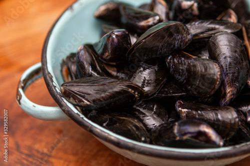 Raw mussels in a blue colander