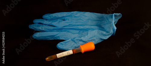 close up healthcare medical mask with blue glove and medical blood collection tube for coronavirus covid 19 on black background photo