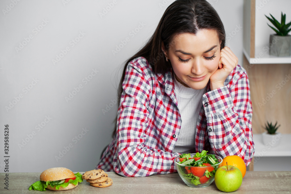 Girl makes a choice between healthy and harmful food Girl makes a choice between healthy and harmful food