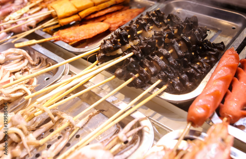 Seafood on wooden sticks for grilling.