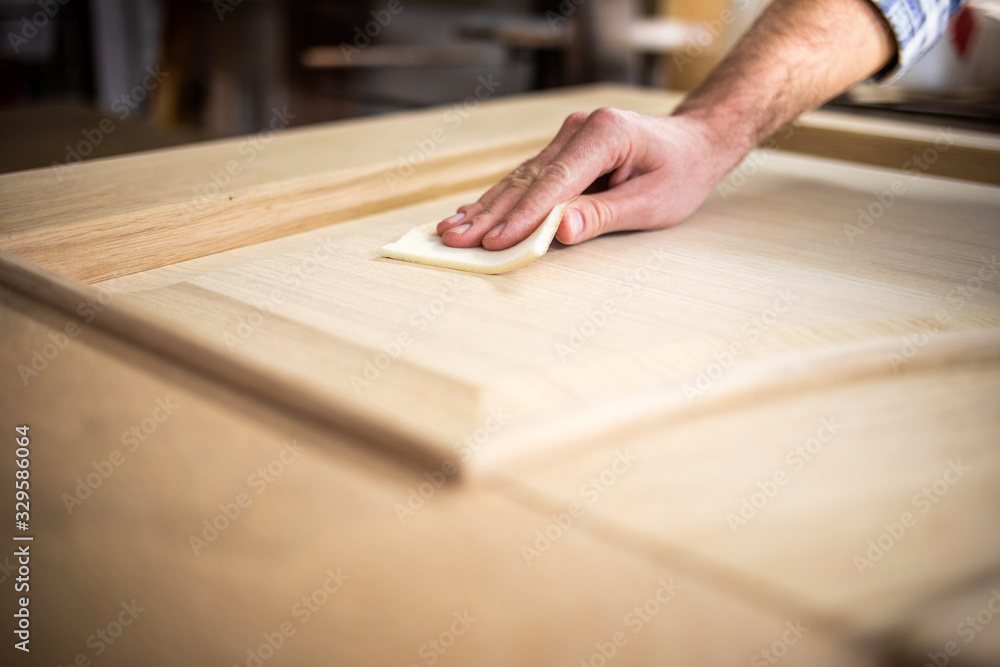 Close up of abrasive paper polishing a wooden board Close up of abrasive paper polishing a wooden board