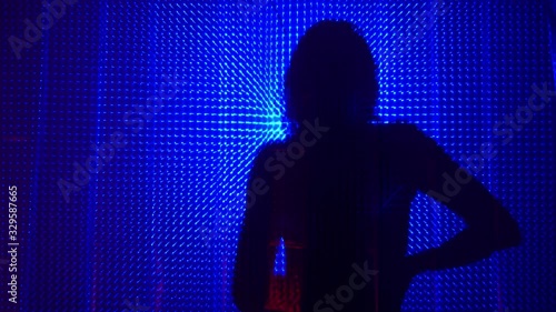 Beauty Model girl dancing shadow silhouette. Beautiful sexy young woman perfect slim body dance in uv light. Silhouette of a girl dancing in the shower behind the curtain