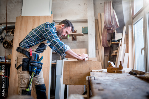 Carpenter working on woodworking in carpentry workshop
