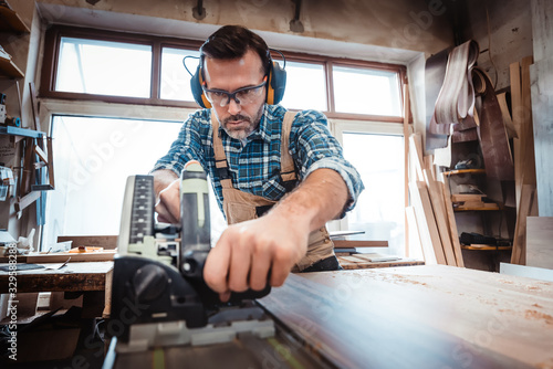 Carpenter working on woodworking in carpentry workshop