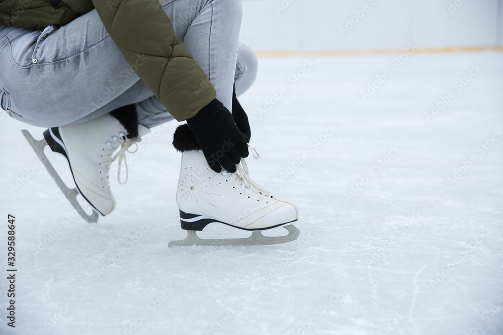 white ice skates is on female legs close up on the ice white ice skates is on female legs close up on the ice