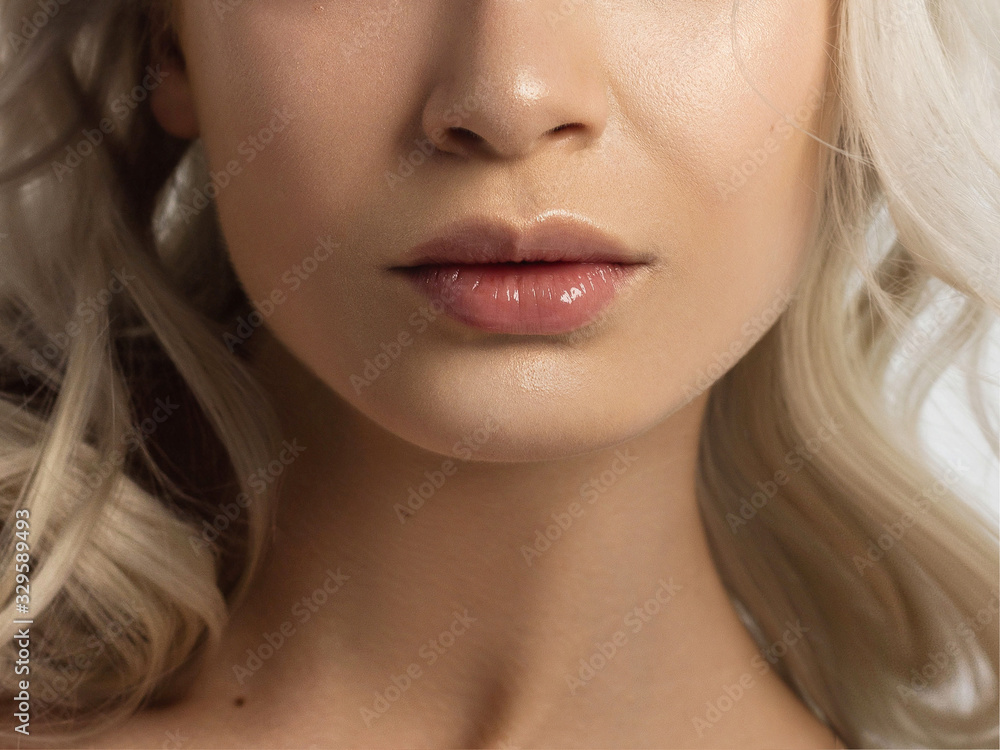 Sexual full lips. Natural gloss of lips and woman's skin. The mouth is closed. Increase in lips, cosmetology. Pink lips and long neck. Gentle pure skin and wavy blonde hair. Sexual full lips. Natural gloss of lips and woman's skin. The mouth is closed. Increase in lips, cosmetology. Pink lips and long neck. Gentle pure skin and wavy blonde hair.