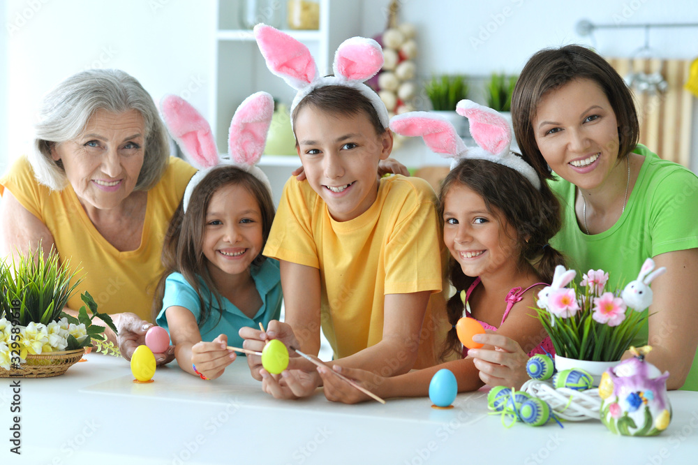 Family painting traditional Easter eggs in different colors at home Family painting traditional Easter eggs in different colors at home