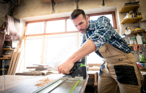 Carpenter using woodworking tools for craft work in carpentry workshop