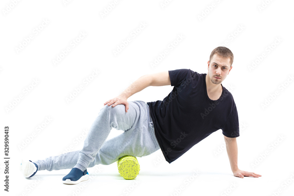 A man makes strengthening exercises for the body with special sports equipment. Self massage increases the body's tone A man makes strengthening exercises for the body with special sports equipment. Self massage increases the body's tone