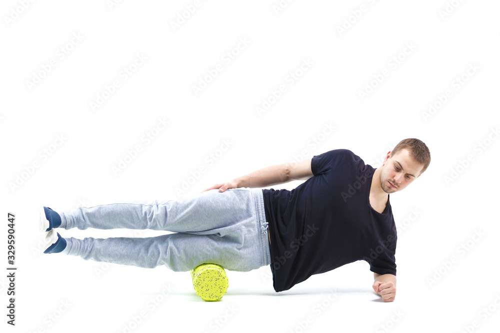 A man makes strengthening exercises for the body with special sports equipment. Self massage increases the body's tone A man makes strengthening exercises for the body with special sports equipment. Self massage increases the body's tone