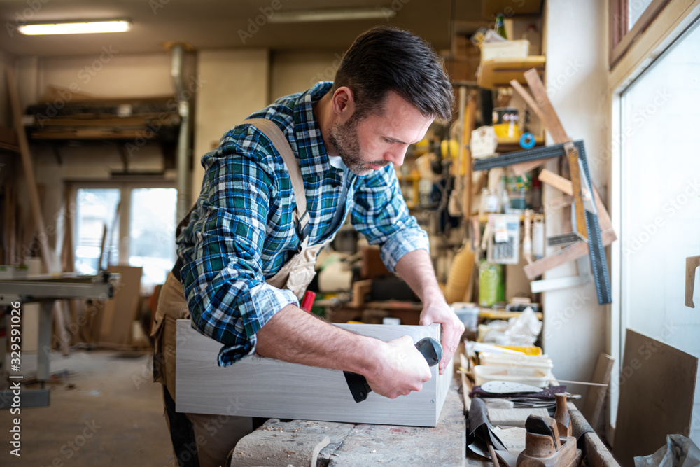 Carpenter using woodworking tools for craft work in carpentry workshop Carpenter using woodworking tools for craft work in carpentry workshop