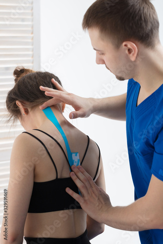 The doctor does the procedure of taping the spine for a young girl