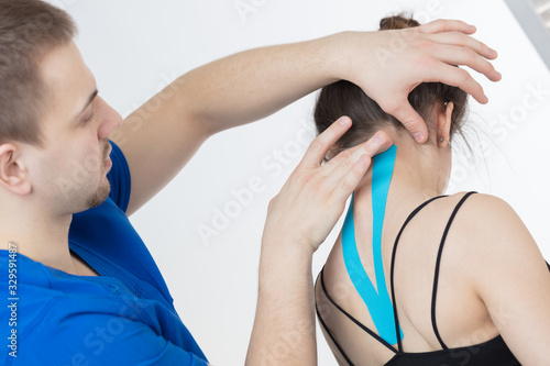 The doctor does the procedure of taping the spine for a young girl