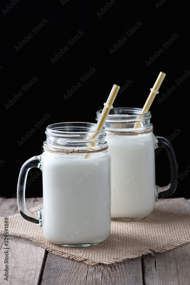 Glass cups with milk on a wooden rustic background Glass cups with milk on a wooden rustic background