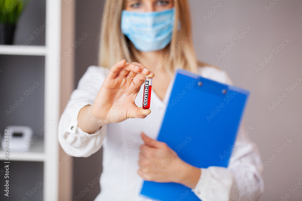 Health worker holds a test tube with a test of covid-2019