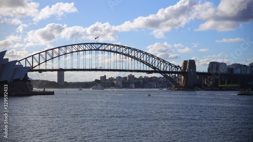 Sydney Harbour on a warm summer afternoon at Sunset blue skies and white orange clouds © Elias Bitar
