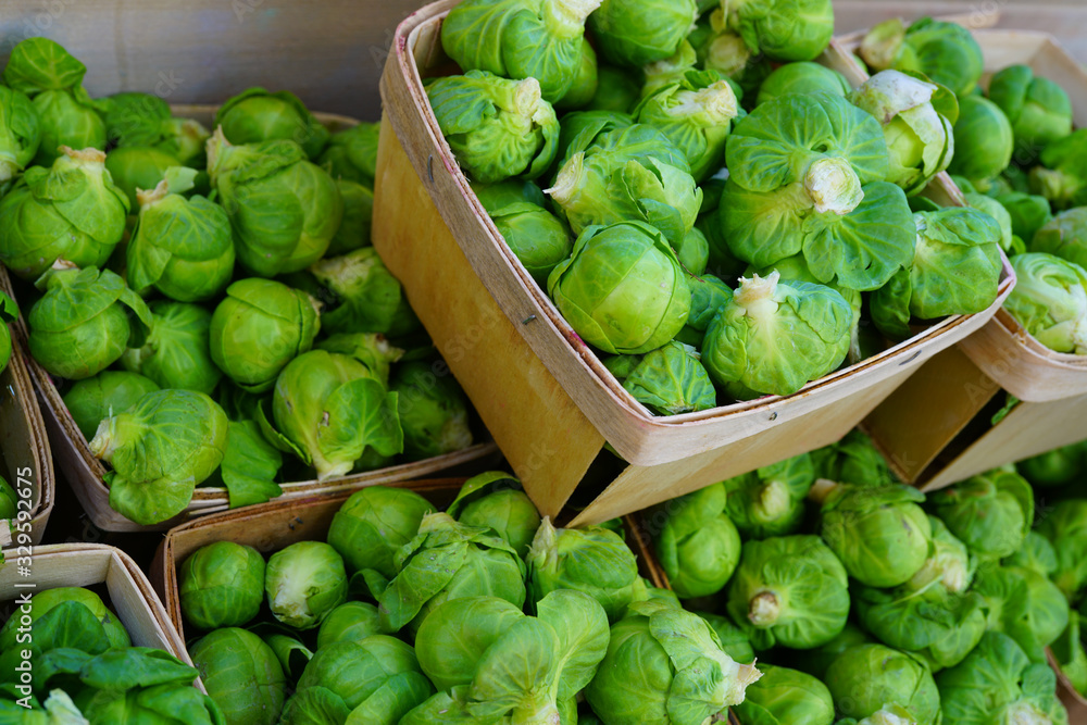 Containers of fresh organic green Brussels sprouts at the farmers market Containers of fresh organic green Brussels sprouts at the farmers market