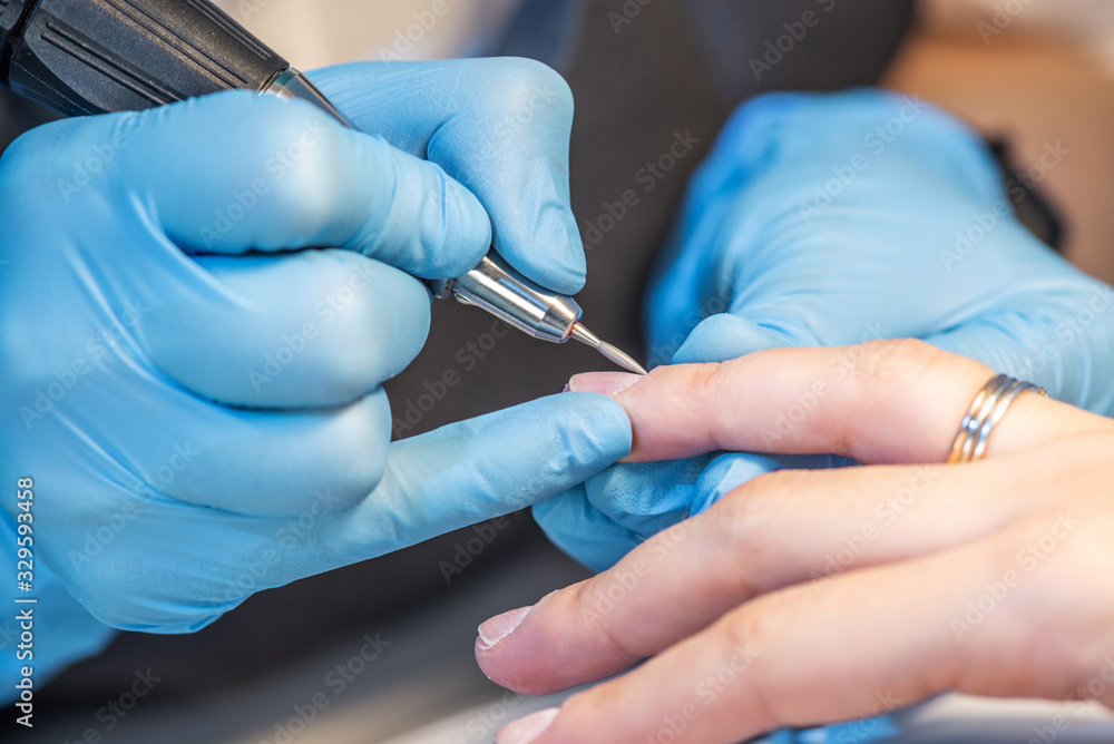 Woman manicure master in the process of working with the client 's nails. Close up. Cosmetology and nail care Woman manicure master in the process of working with the client 's nails. Close up. Cosmetology and nail care