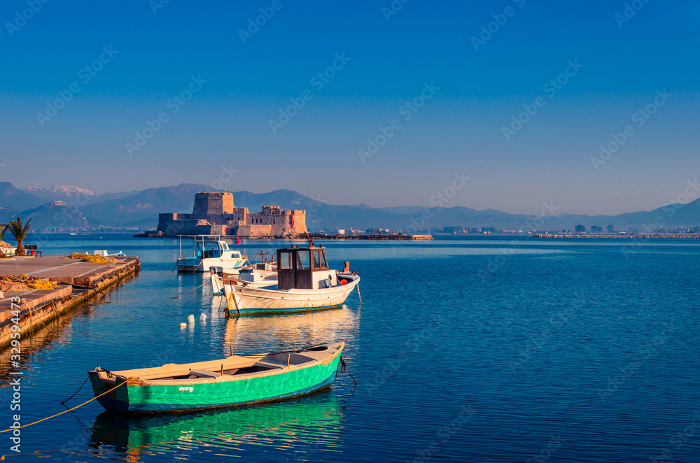 Nafplio Greece- View of the beautiful port of Nafplio with small boats and the castle of Bourtzi at sunset.