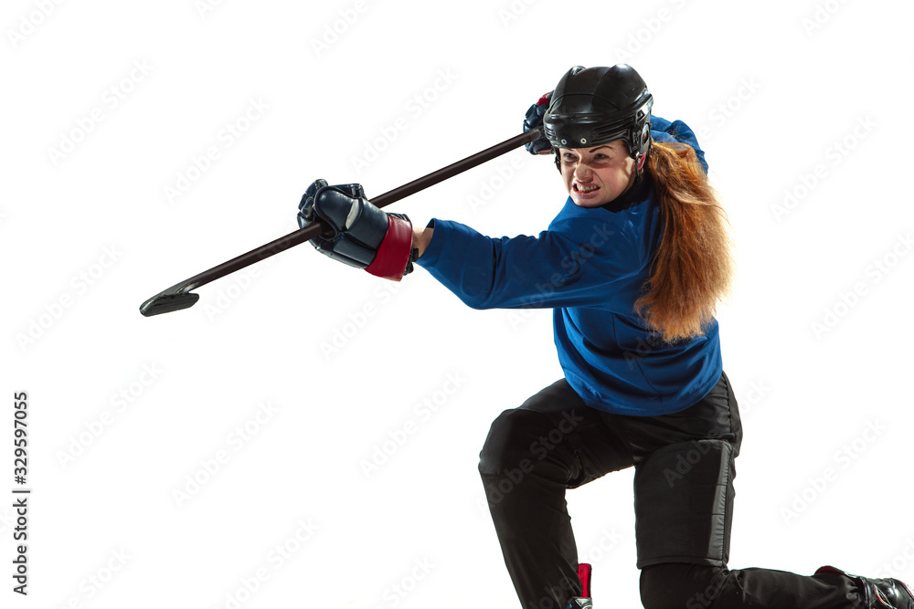 Young female hockey player with the stick on ice court and white background. Sportswoman wearing equipment and helmet training. Concept of sport, healthy lifestyle, motion, action, human emotions. Young female hockey player with the stick on ice court and white background. Sportswoman wearing equipment and helmet training. Concept of sport, healthy lifestyle, motion, action, human emotions.