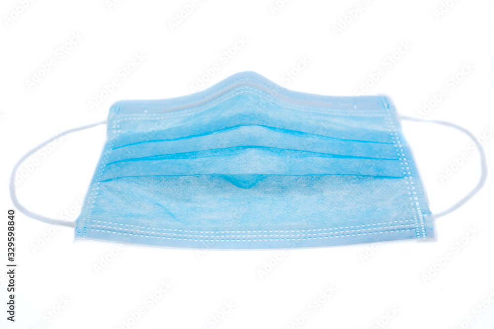 Fototapeta premium Medical mask of blue color for protection against flu or virus, epidemic and other diseases. Medical respiratory bandage face on white background.