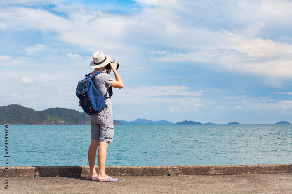 travel photographer, man traveler taking photo of sea and wearing backpack, unrecognizable tourist photographing landscape