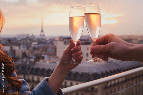 couple drinking champagne or wine in Paris luxurious restaurant with view of Eiffel tower, luxury romantic getaway honeymoon