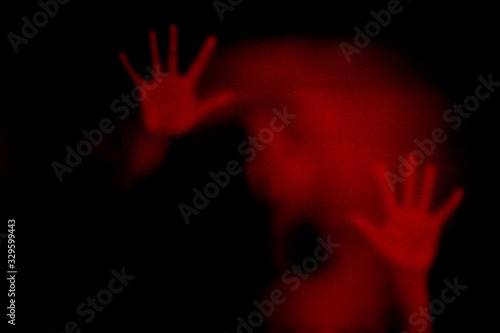 Red shadow of woman on the frosted glass representing dangerous, fear, help, haunting, horror, scary, lockdown, infected, virus and plague