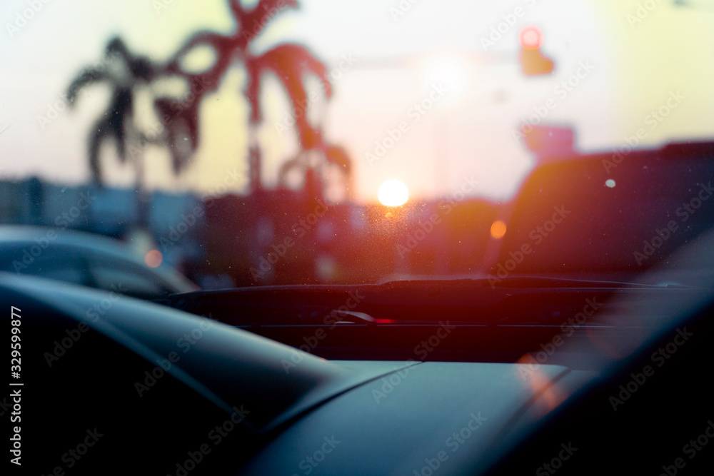 Abstract and blurred front console of the car hits the golden sun at dusk.