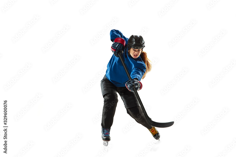 Young female hockey player with the stick on ice court and white background. Sportswoman wearing equipment and helmet training. Concept of sport, healthy lifestyle, motion, action, human emotions.