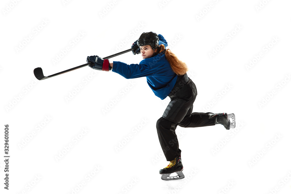 Young female hockey player with the stick on ice court and white background. Sportswoman wearing equipment and helmet training. Concept of sport, healthy lifestyle, motion, action, human emotions. Young female hockey player with the stick on ice court and white background. Sportswoman wearing equipment and helmet training. Concept of sport, healthy lifestyle, motion, action, human emotions.